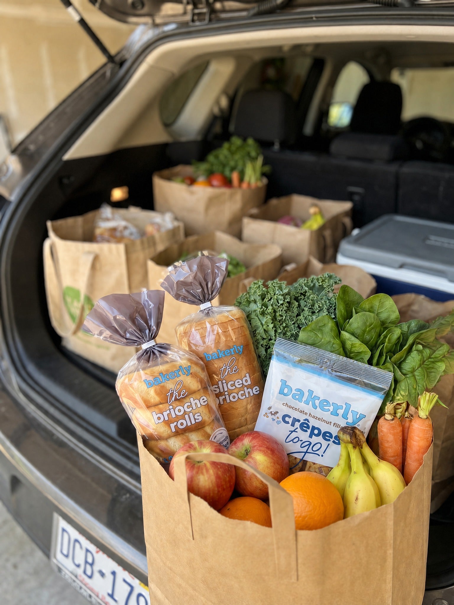 bakerly products and fresh groceries packed in a car for back-to-school routines